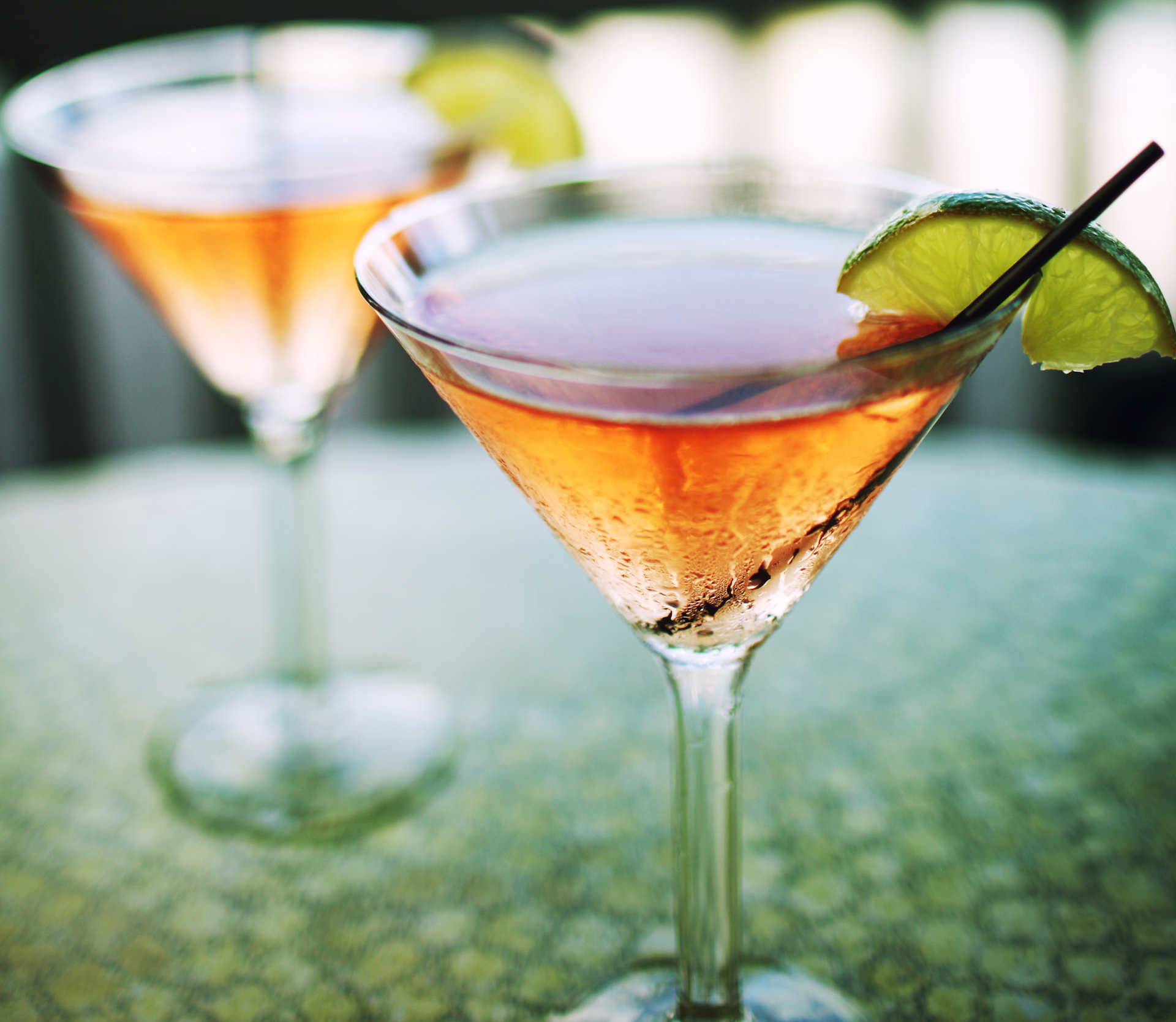 Two glasses of Watermelon Martini on a green table