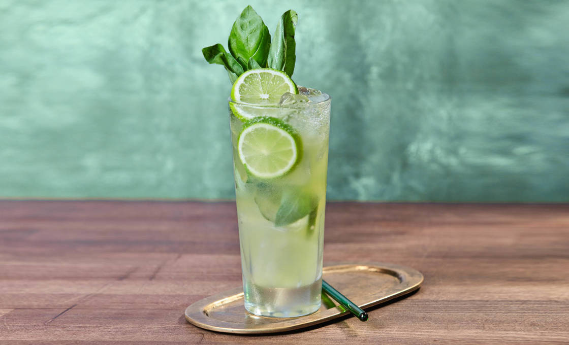 A glass of Virgin Basil Spritz on a metal serving plate