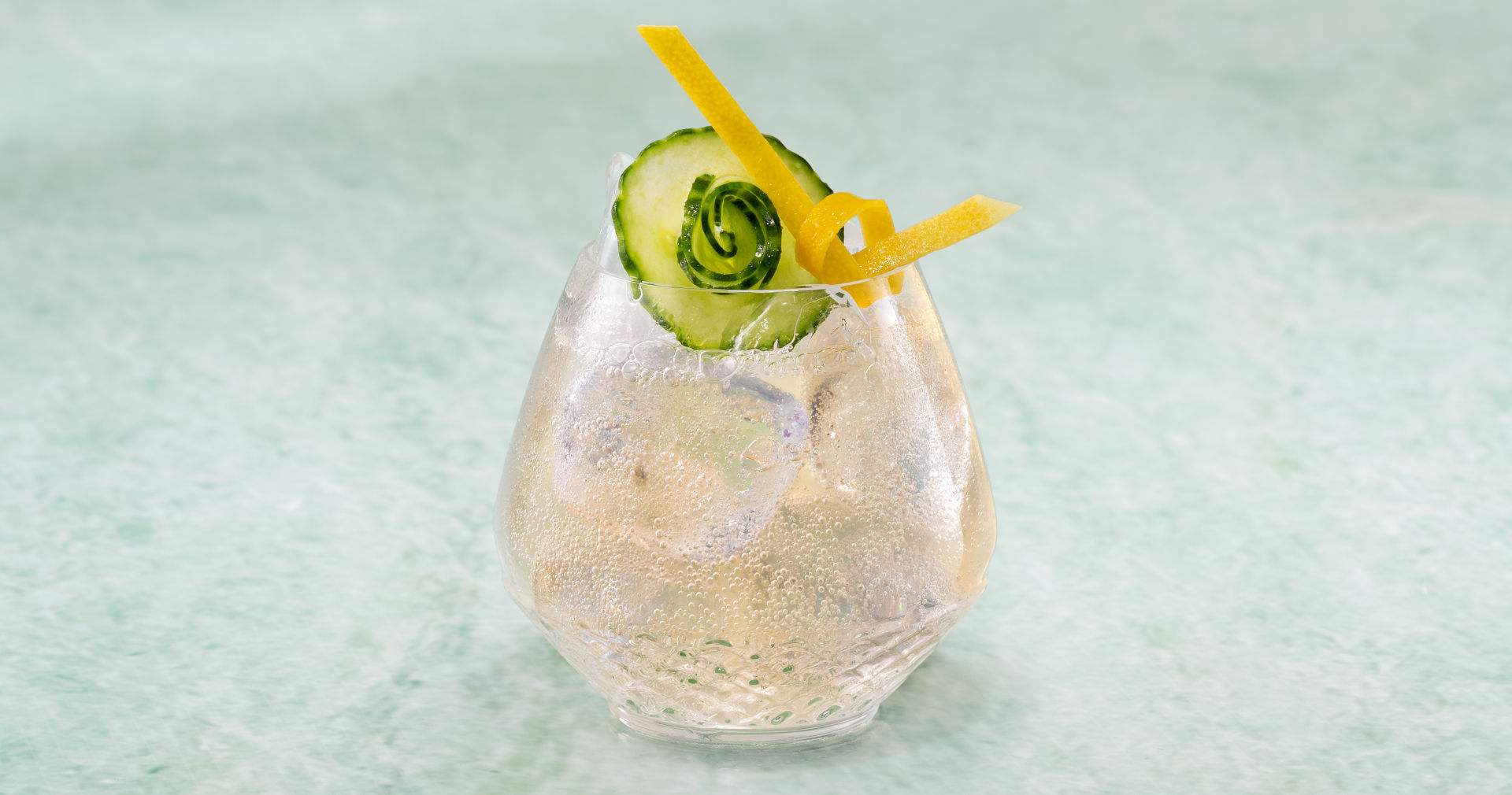 Yuzu And Cucumber Soda sitting on a green surface