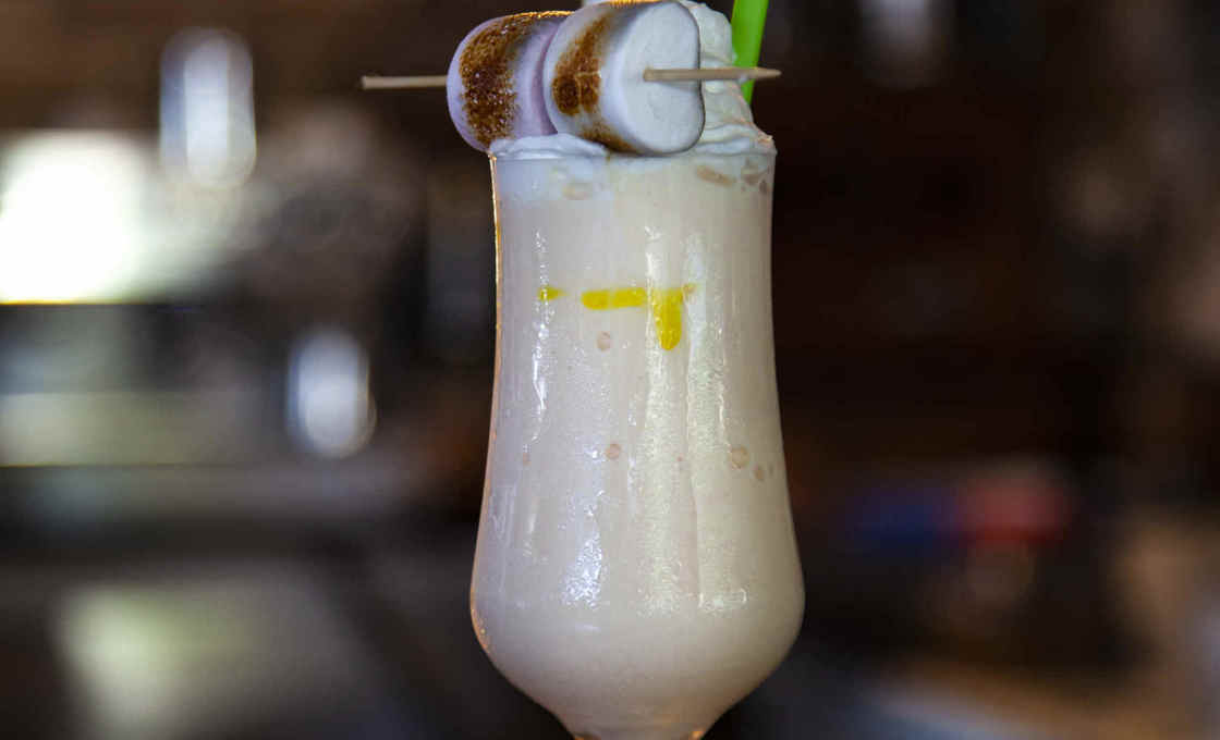 Glass of Iced Tiramisu Chocolate on a wooden board with marshmallows 