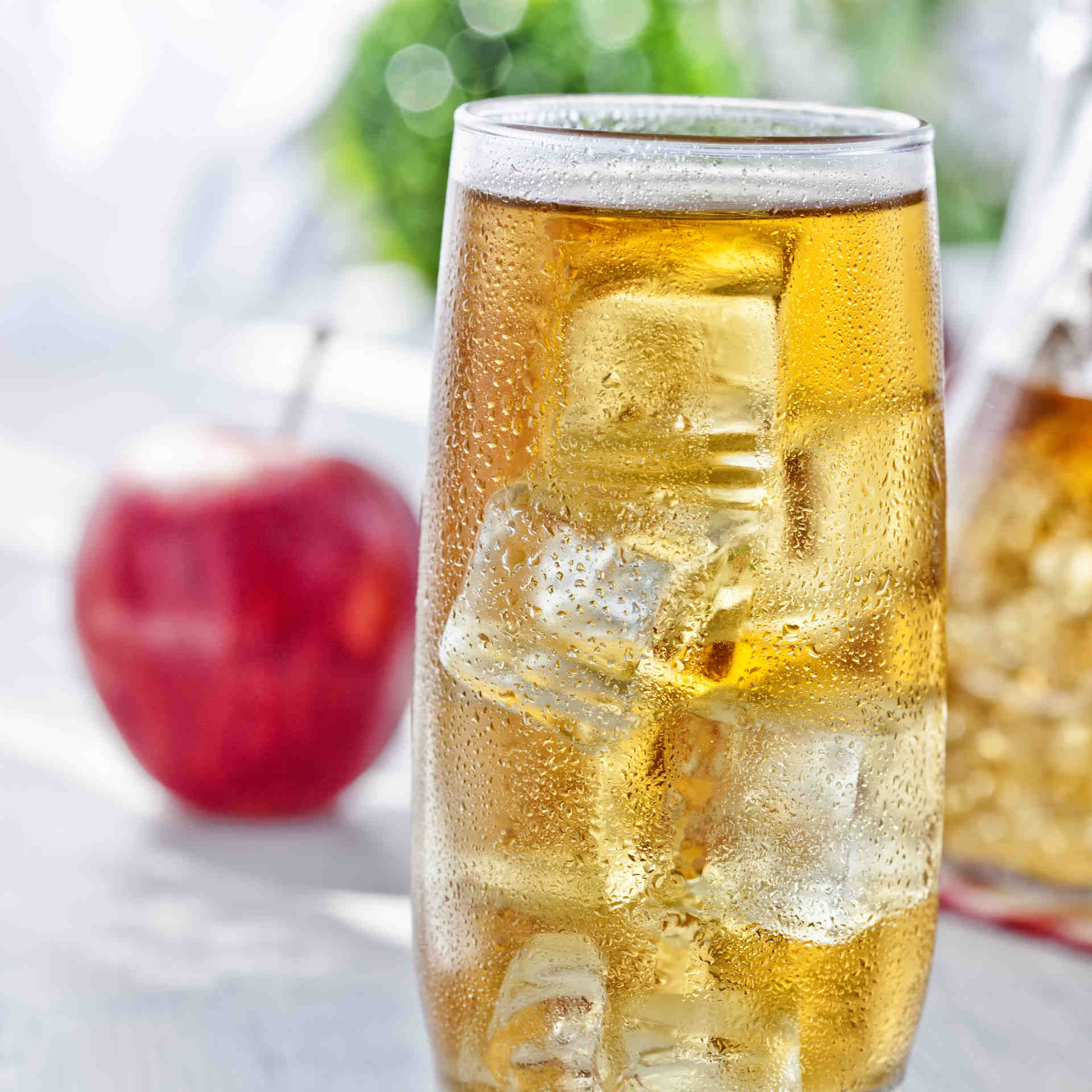 A glass of American pie with an apple in the background