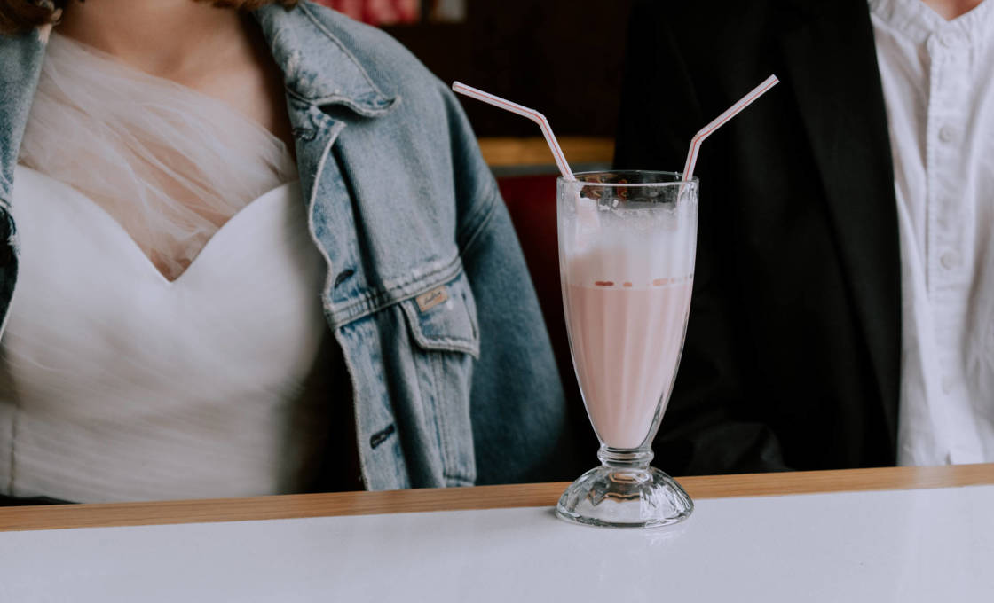 Man and a woman sitting with a Candy Apple Hardshake