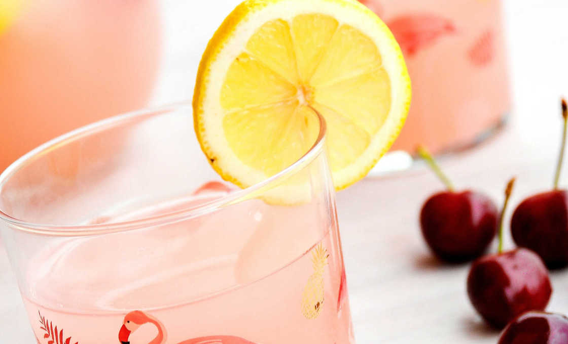 Sunrise cocktail in a flamingo glass with cherries 