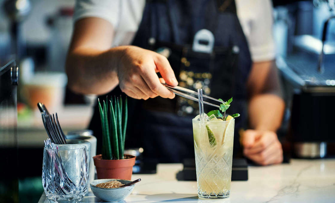 Bartender garnishing a class of Icy Tonic
