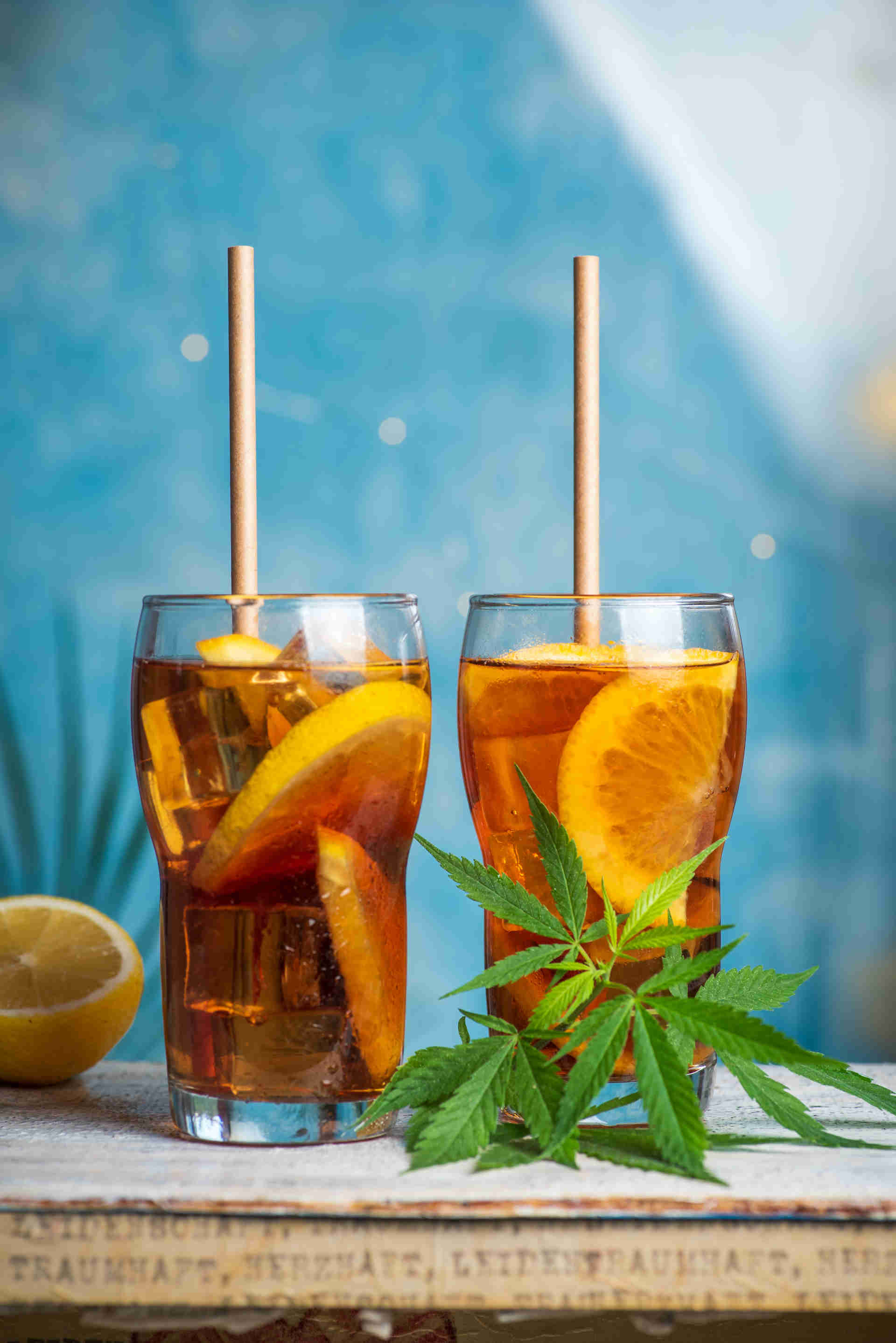 Two glasses on a table with half a lemon and mint sprigs