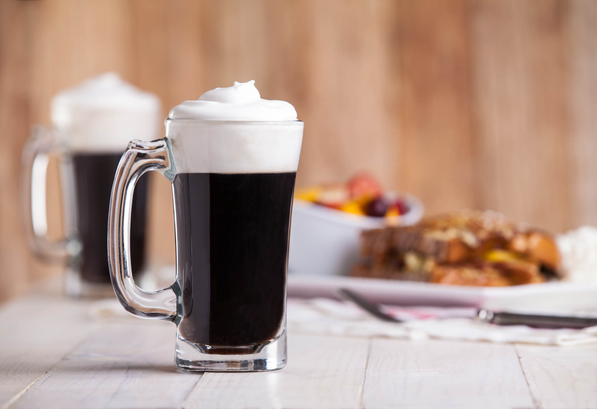 Two glasses of Rosemary Irish Coffee with whipped cream on top