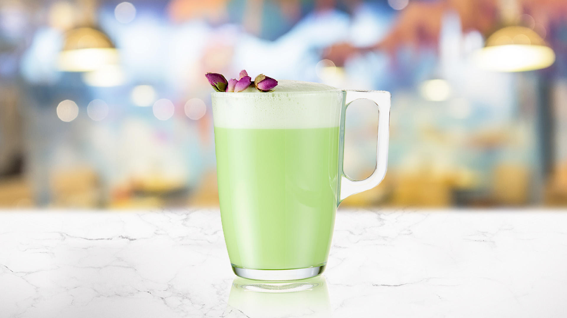 Glass of Pandan Vanilla Latte on a marble counter