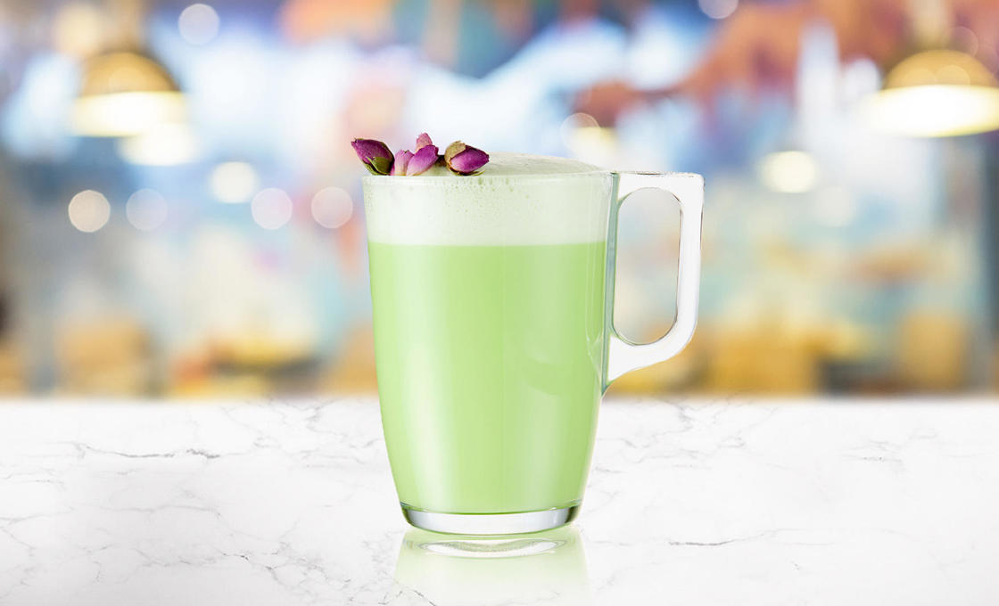 Glass of Pandan Vanilla Latte on a marble counter