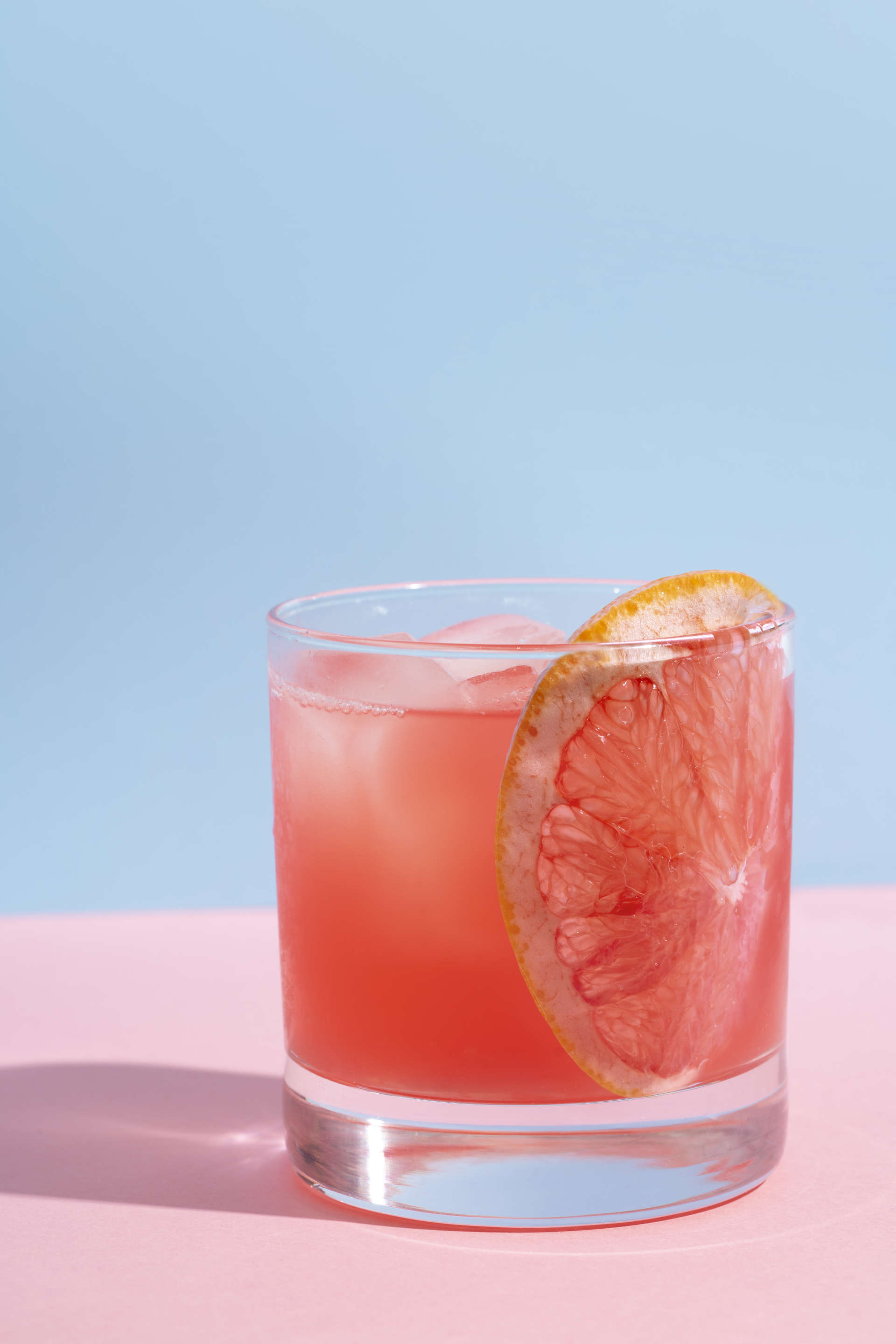 A glass of Pomme Peach on a pink table