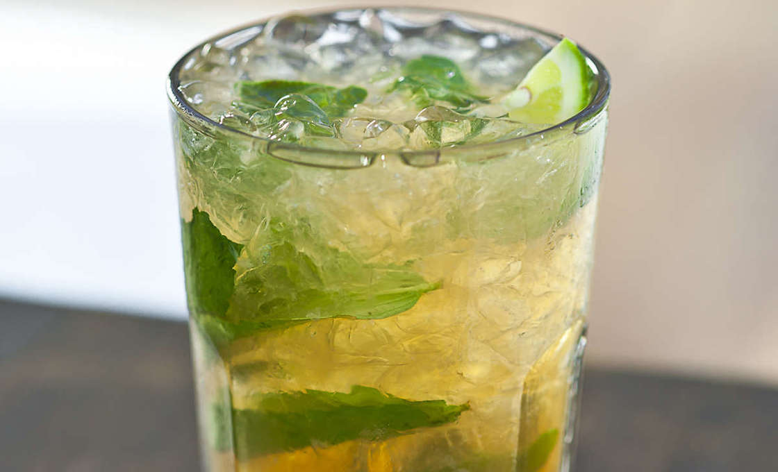 Glass of Triple Caiprinha on a wooden table