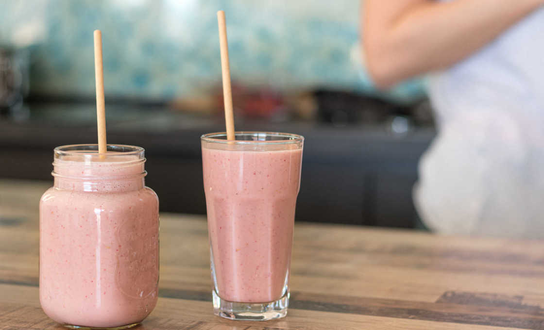 Two glasses of Candy Apple Shake with a woman in the background