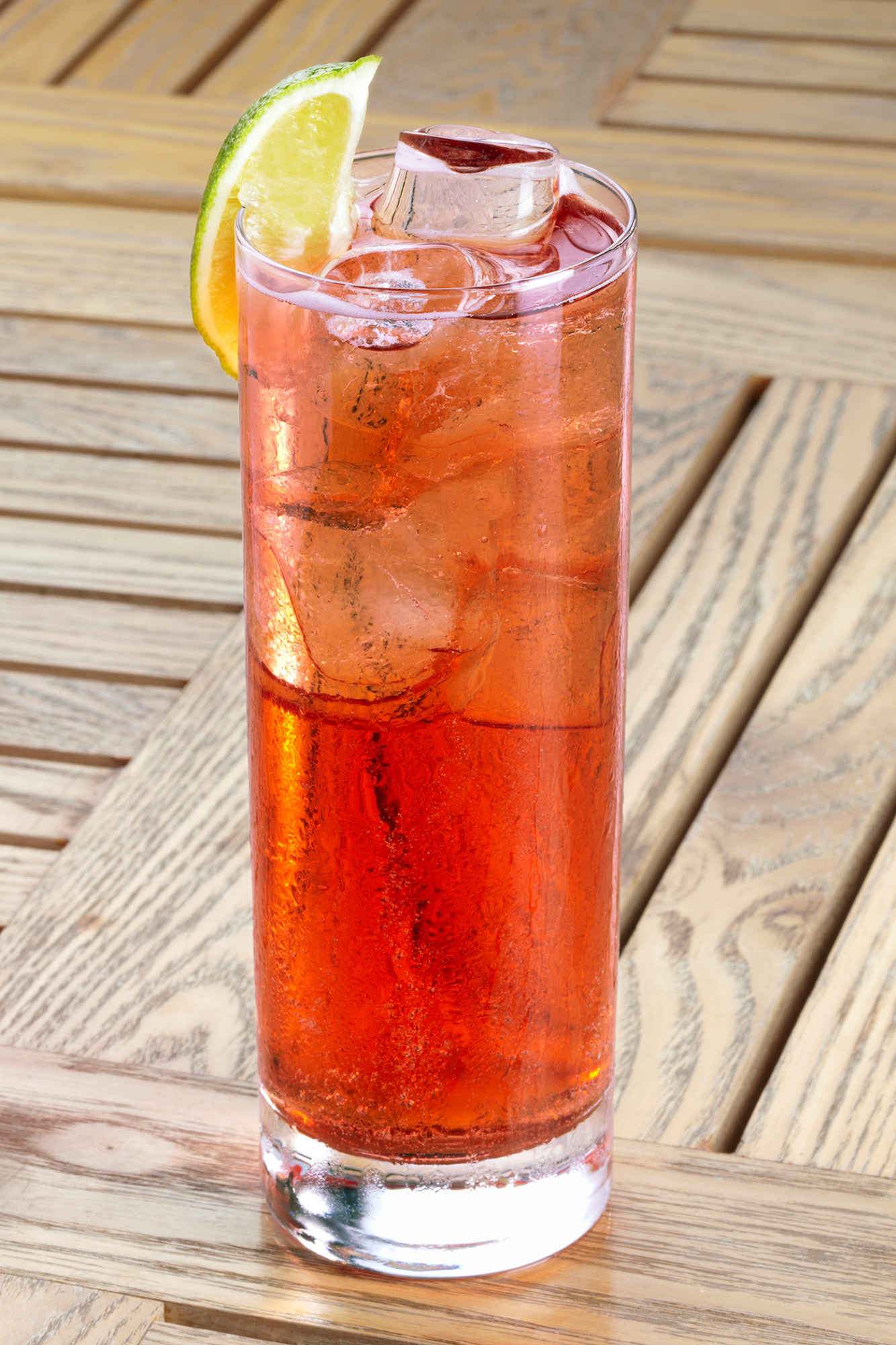 Tall glass of Cherry & Peach Sparkler on a wooden table