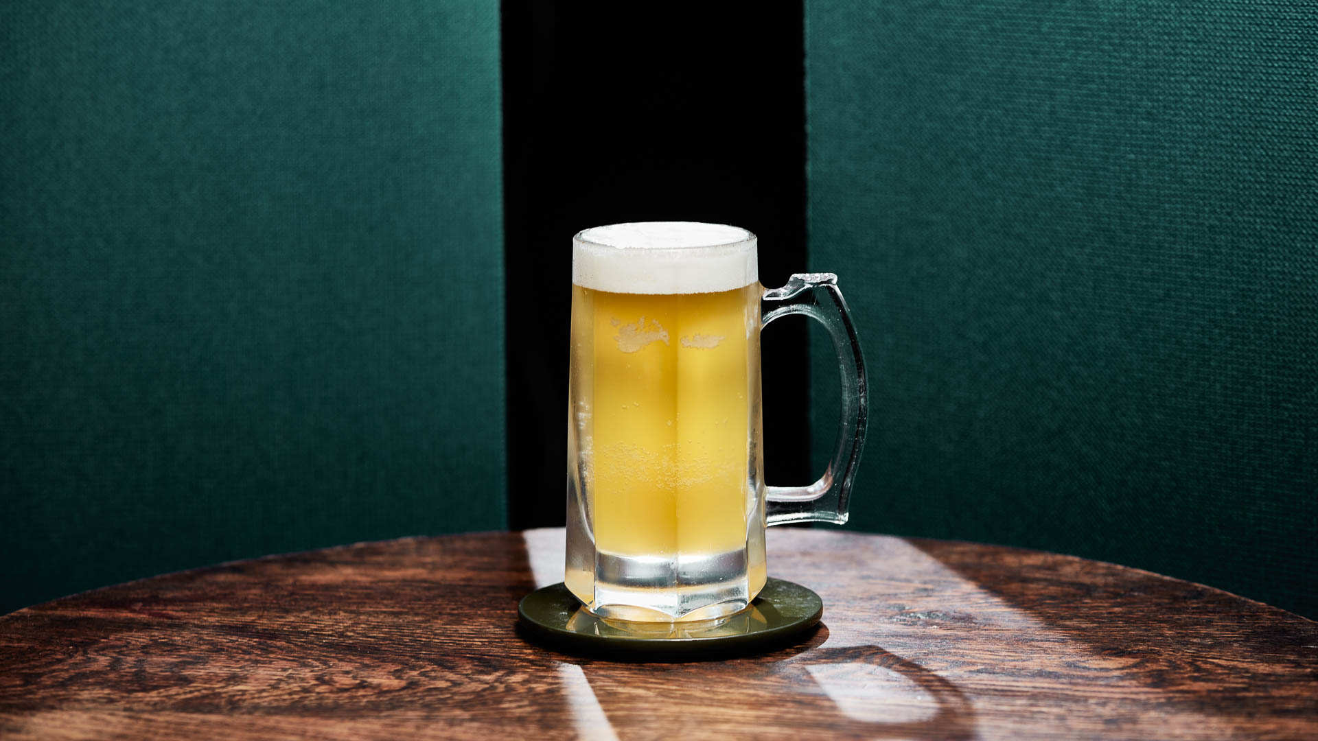 A glass of Lager Tropicale on a wooden table