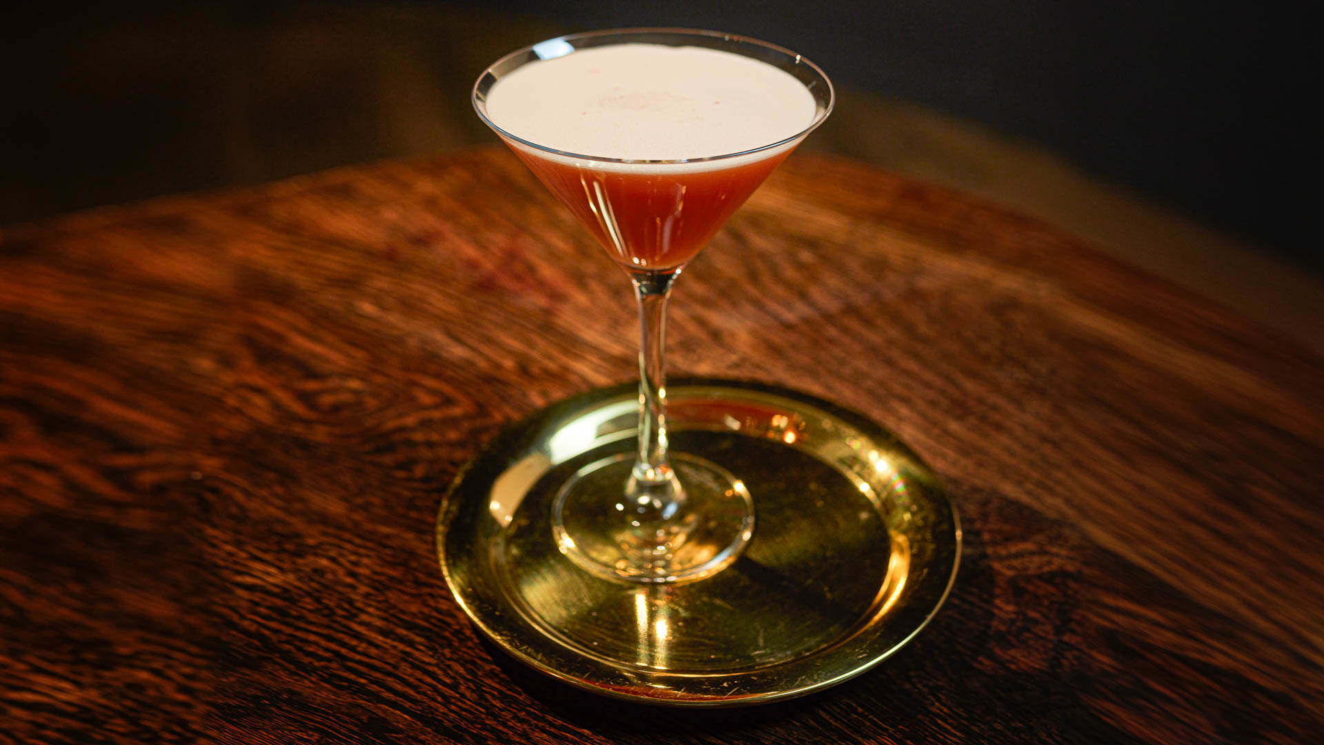 A glass of Shaky Granate on a dark wooden table