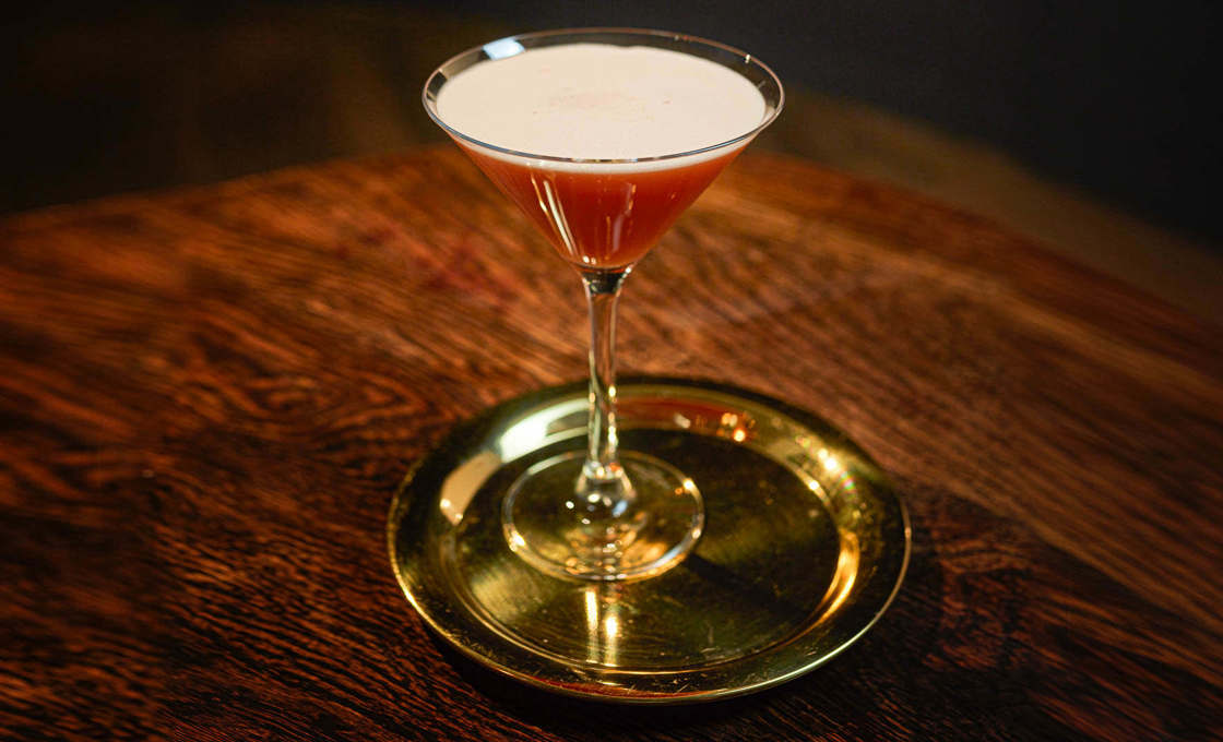 A glass of Shaky Granate on a dark wooden table