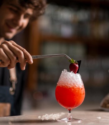 Elevate Your Skills Carousel2 Bartender Adding A Strawberry To An Icy Cocktail