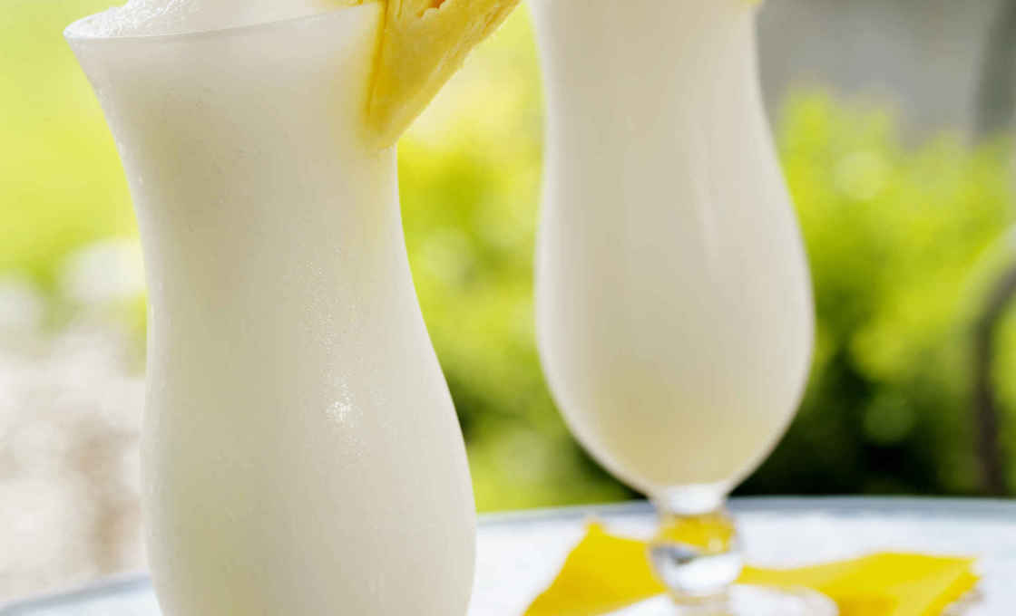 Two glasses of Pina Colada Shake on a glass table outside